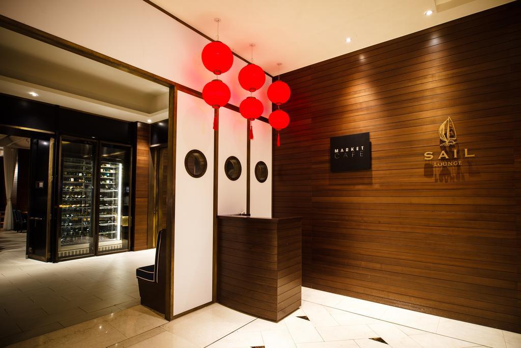 Ambassador Hotel Kaohsiung Exterior photo The photo shows the interior of a restaurant or establishment named "SAIL." The entrance features a wooden wall with a logo displayed prominently. There are decorative red lanterns hanging above the reception area, which has a sleek, modern design. O