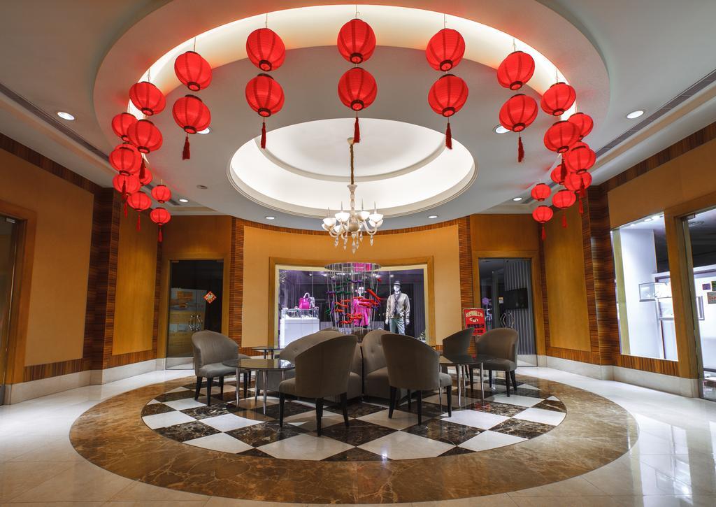 Ambassador Hotel Kaohsiung Exterior photo The photo depicts an elegant interior space featuring a circular seating area. The ceiling is adorned with several red lanterns, creating a festive atmosphere. There is a circular chandelier in the center, contributing to the overall ambiance. The fl